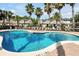 Community pool surrounded by lounge chairs and palm trees, perfect for relaxation at 10374 Park Commons Dr, Orlando, FL 32832