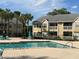 Community pool area with comfortable lounge chairs, tables, and beautifully landscaped surroundings at 1065 S Hiawassee Rd # 1434, Orlando, FL 32835