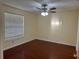 Bedroom features dark wood floors, a ceiling fan, and a window bringing in natural light at 1079 S Hiawassee Rd # 1121, Orlando, FL 32835
