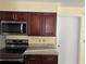 Kitchen with stainless steel appliances, dark wood cabinets, and light countertops, offering modern convenience at 1079 S Hiawassee Rd # 1121, Orlando, FL 32835