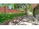 Well-maintained backyard featuring a brick wall, paver patio, mature trees and greenery, creating a private outdoor oasis at 1156 Brandy Lake View Cir, Winter Garden, FL 34787