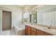Well-lit bathroom with a tub, a tiled shower, a double sink vanity, and decorative wall accents at 1156 Brandy Lake View Cir, Winter Garden, FL 34787