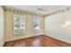 Inviting bedroom with hardwood floors, a ceiling fan, and natural light from two windows at 1156 Brandy Lake View Cir, Winter Garden, FL 34787