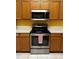 Close-up of stainless steel oven and microwave with wood cabinets in the kitchen at 1156 Brandy Lake View Cir, Winter Garden, FL 34787