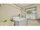 Functional laundry room features a utility sink and a window with cheery lemon-themed curtains at 1156 Brandy Lake View Cir, Winter Garden, FL 34787