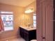 Bright bathroom with a double sink vanity, large mirror, and a window providing natural light and neighborhood views at 11746 Water Run Aly, Windermere, FL 34786