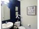 Stylish half bathroom with modern sink, fixtures, and navy accent wall at 11746 Water Run Aly, Windermere, FL 34786