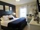 Well-lit bedroom featuring a comfortable bed, dark accent wall, and a vanity with a mirror and jewelry display at 11746 Water Run Aly, Windermere, FL 34786
