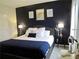 Stylish bedroom with a navy accent wall and lamps on each bedside table providing a relaxing ambiance at 11746 Water Run Aly, Windermere, FL 34786