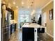 Bright, modern kitchen features stainless steel appliances, an island with seating, and pendant lighting at 11746 Water Run Aly, Windermere, FL 34786