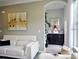 Comfortable living room with white couch and unique wall art above, plus an archway leading to another room at 11746 Water Run Aly, Windermere, FL 34786