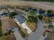 Aerial view showing a landscaped yard, mature trees, and a driveway leading to a well-maintained home at 119 Argyle Gate Loop Rd, Dundee, FL 33838
