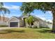 Charming single-story home with a well-maintained lawn, gray exterior, and a two-car garage at 119 Argyle Gate Loop Rd, Dundee, FL 33838