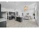 Bright, open kitchen featuring stainless appliances, dark gray cabinets, island, and decorative gold chandelier at 119 Argyle Gate Loop Rd, Dundee, FL 33838