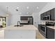 Stylish kitchen showcasing dark cabinets, stainless steel appliances, and a large island with white countertop at 119 Argyle Gate Loop Rd, Dundee, FL 33838