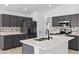 Modern kitchen features gray cabinetry, stainless appliances, and a central island with white countertop at 119 Argyle Gate Loop Rd, Dundee, FL 33838