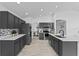 Modern kitchen featuring dark cabinets, stone countertops, and stainless steel appliances at 119 Argyle Gate Loop Rd, Dundee, FL 33838