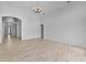 Expansive living room with sleek wood-look floors, arched doorways, and contemporary light fixtures at 119 Argyle Gate Loop Rd, Dundee, FL 33838