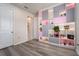 A bedroom is furnished with a pink and gray shelving unit and wood flooring at 13864 Destin Beach Ln, Orlando, FL 32827