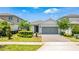 Charming single-story home with a well-manicured lawn, lush landscaping, and a two-car garage at 13864 Destin Beach Ln, Orlando, FL 32827