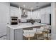 Contemporary kitchen with white cabinetry, a gray island, and luxurious gold bar stools at 13864 Destin Beach Ln, Orlando, FL 32827