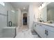 Elegant bathroom with a glass-enclosed shower, dual vanity, and marble flooring leading to the walk-in closet at 13864 Destin Beach Ln, Orlando, FL 32827