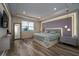 Serene main bedroom features a tray ceiling, ambient lighting, and modern furnishings for ultimate relaxation at 13864 Destin Beach Ln, Orlando, FL 32827