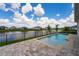 Backyard pool view showcases a peaceful waterfront view surrounded by beautiful blue skies at 13864 Destin Beach Ln, Orlando, FL 32827