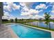 A refreshing pool with a serene waterfront view creates a perfect outdoor oasis at 13864 Destin Beach Ln, Orlando, FL 32827