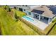 Aerial view of the pool and backyard, featuring solar panels, a patio area, and manicured lawn at 13864 Destin Beach Ln, Orlando, FL 32827