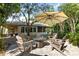 Backyard patio featuring an outdoor sitting area with umbrella, mature trees, and lush greenery at 14841 Faversham Cir, Orlando, FL 32826