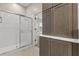 Modern bathroom with glass-enclosed shower, and wood cabinets at 14841 Faversham Cir, Orlando, FL 32826