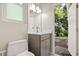 Cozy bathroom with a single sink vanity, granite counters, and an adjacent outdoor view from the open door at 14841 Faversham Cir, Orlando, FL 32826