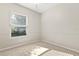 Neutral bedroom with a large window showing the outdoor greenery, carpet, and baseboard trim at 14841 Faversham Cir, Orlando, FL 32826
