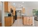 Open kitchen features a center island, stainless appliances, and ample wood cabinets at 14841 Faversham Cir, Orlando, FL 32826