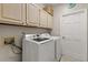 Laundry room complete with front loading washer and dryer, storage cabinets, and tile flooring at 14841 Faversham Cir, Orlando, FL 32826