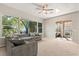 Bright living room with large windows offering views of the landscaped backyard and outdoor living area at 14841 Faversham Cir, Orlando, FL 32826