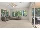 Bright living room with large windows offering views of the landscaped backyard and outdoor living area at 14841 Faversham Cir, Orlando, FL 32826