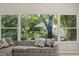 Cozy living room featuring a comfortable couch, large windows with a view of the serene backyard at 14841 Faversham Cir, Orlando, FL 32826