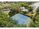 Aerial view of well-maintained tennis courts adjacent to a beautiful pool and lush landscaping at 14841 Faversham Cir, Orlando, FL 32826
