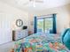 Bright bedroom with ceiling fan, screened-in patio, dresser with mirror and floral comforter at 16604 Caribbean Breeze Way, Clermont, FL 34714
