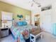 Bright bedroom with ceiling fan, ensuite bathroom, colorful floral comforter and decorative bench at 16604 Caribbean Breeze Way, Clermont, FL 34714