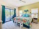 Bright bedroom with ceiling fan, screened-in patio, colorful floral comforter and decorative bench at 16604 Caribbean Breeze Way, Clermont, FL 34714