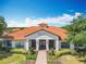 Stunning High Grove Clubhouse featuring a tile roof and beautifully landscaped grounds at 16604 Caribbean Breeze Way, Clermont, FL 34714