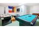 Brightly lit game room featuring a pool table, air hockey, TV and decorative flags for endless entertainment possibilities at 16604 Caribbean Breeze Way, Clermont, FL 34714