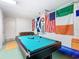 Game room featuring a pool table under international flags, offering a variety of entertainment options at 16604 Caribbean Breeze Way, Clermont, FL 34714