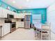 White kitchen featuring stainless steel appliances, ample counter space, and bright blue accent wall at 16604 Caribbean Breeze Way, Clermont, FL 34714