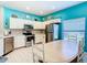 Open concept kitchen with stainless steel appliances, blue accent wall, and dining table at 16604 Caribbean Breeze Way, Clermont, FL 34714