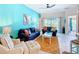 Comfortable living room with bright blue walls, plush seating, and access to the screened-in pool at 16604 Caribbean Breeze Way, Clermont, FL 34714