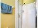 Neutral-colored tiled shower with handheld shower head and a blue towel hanging near the shower door at 16604 Caribbean Breeze Way, Clermont, FL 34714